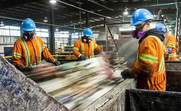 Workers sort through the trash at the Otter Lake Landfill. - RILEY SMITH