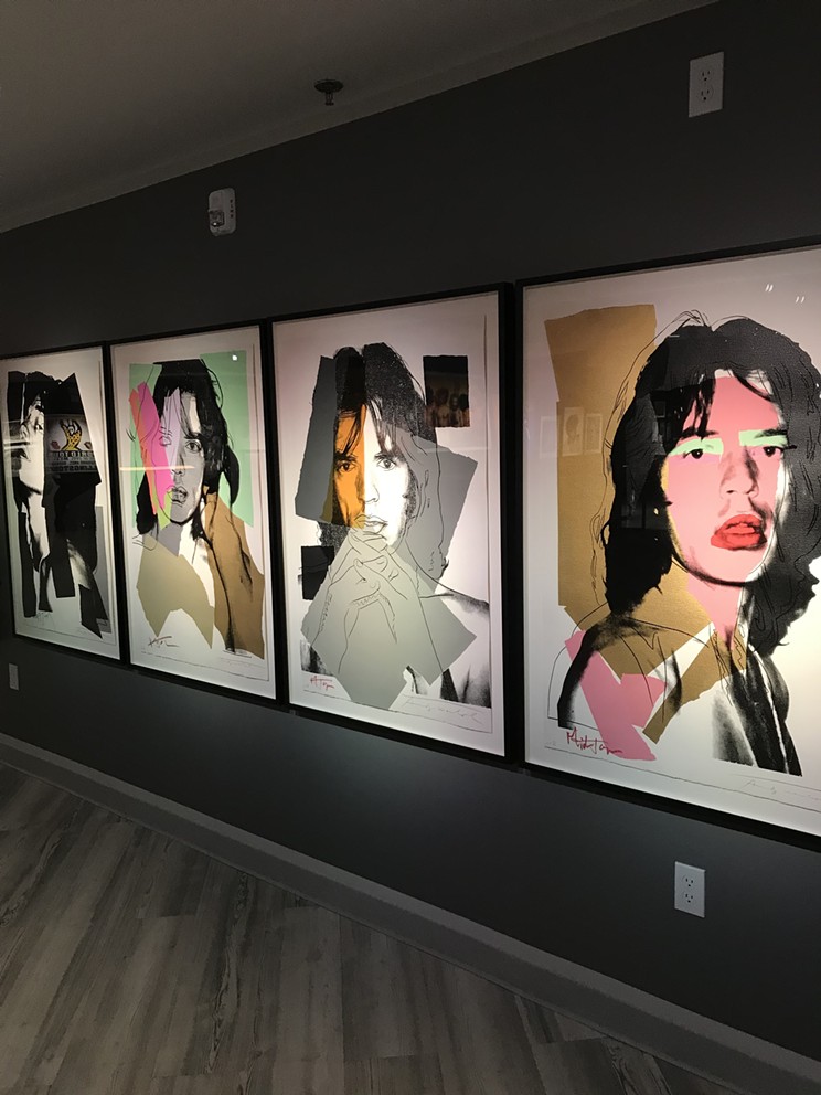 A collection of Andy Warhol portraits of members of The Rolling Stones, on view at the UNZIPPED exhibit.