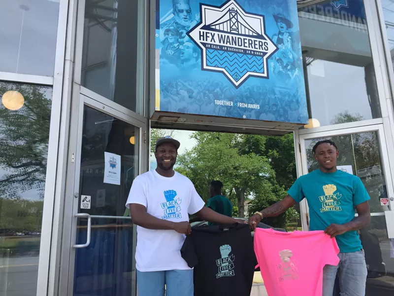 Marvin Okello and Birt Beal show off a t-shirt outside the Quinpool Road Wanderers store. - HFX WANDERERS FC