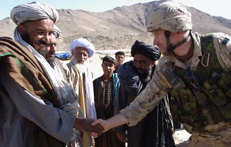 Trevor shaking hands with Afghan locals. - SUBMITTED