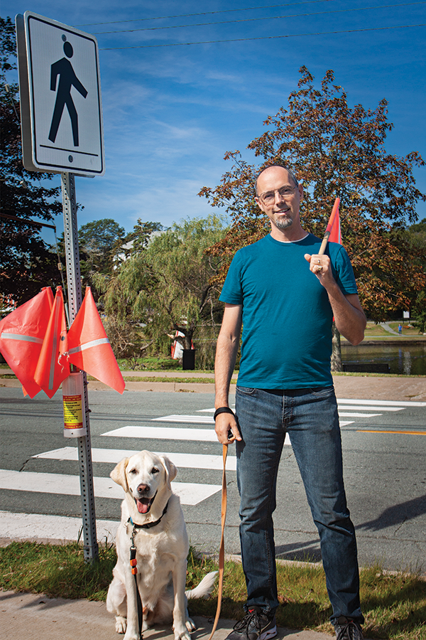 Matt Spurway (above) walks Ajax using flags like those installed near 3D crosswalk in Dartmouth. - SUBMITTED