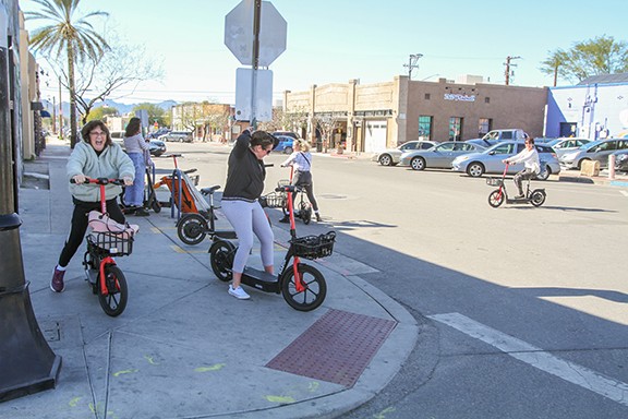 Tourists on Fourth Avenue decide to use scooters to see the Old Pueblo, instead of hoofing it.