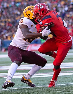 Arizona’s J.J. Taylor, right, tries to spin away from Arizona State’s Ashari Crosswell. - PHOTOS BY SIMON ASHER