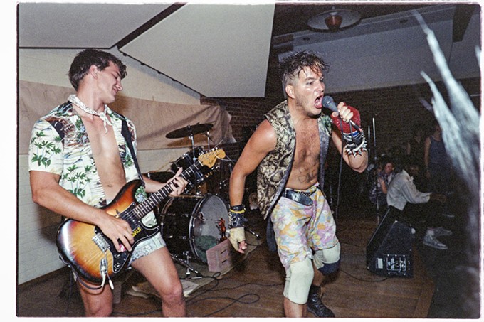 "The Vandals at the Unitarian Universalist Church on 22nd St. in Tucson, 1984.  During the show lead singer Stevo Jensen used a funnel to ingest enough beer to immediately regurgitate it on stage.  Pictured is Jan Nils Ackermann on guitar and Stevo Jensen on vocals. The spiky hair belonged to Lenny Mental who was also in attendance." - ED ARNAUD