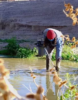 Isaiah Kortright pulls trash out of the Santa Cruz River in Tucson, Ariz. on Jan. 24, 2021. While the area is much cleaner due to the efforts of local stewards, garbage continues to appear along the river due to the urban nature of the environment.