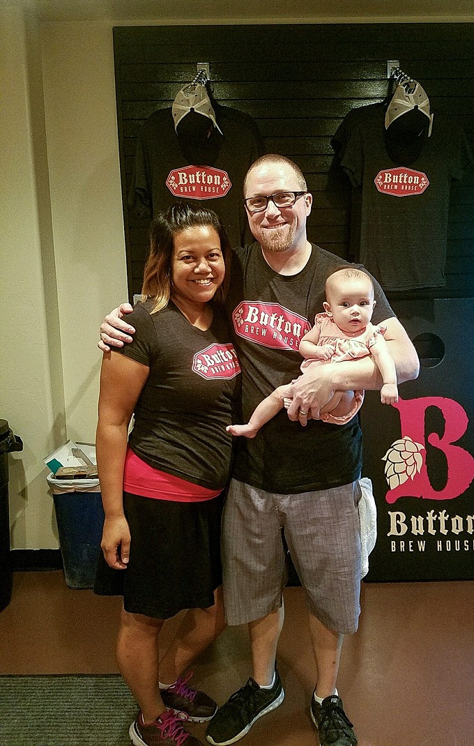 Todd and Erika Button with their youngest daughter, Vivienne, at the soft opening of their new microbrewery, Button Brewhouse.