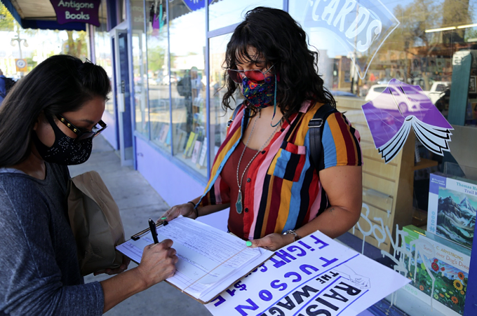 Tucson Fight for $15 volunteer Brittany Fitzgerald collects signatures on Fourth Avenue to get the Tucson Minimum Wage Act on the ballot this November. The legislation would gradually increase the minimum wage in Tucson to $15 by 2025.