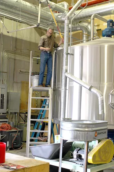 Stephen Paul checks barley in a prototype combination germination and kilning tank. - HEATHER HOCH