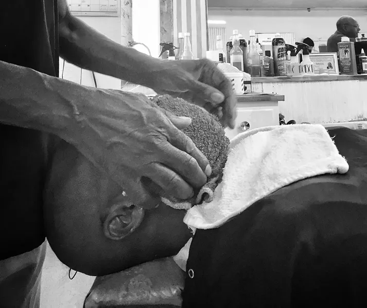 Johnelle Hunter shaves another customer. - BRIAN SMITH